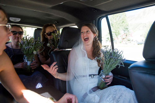 bride and bridesmaids ride in car holding bouquets