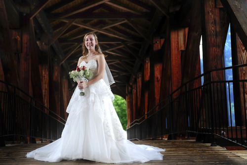 bride standing on covered bridge