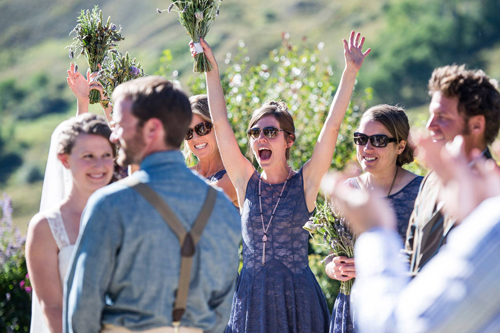 bridesmaid cheering and holding bouquet in the air