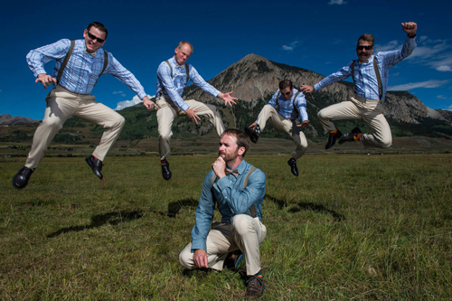 groomsmen jump around kneeling groom